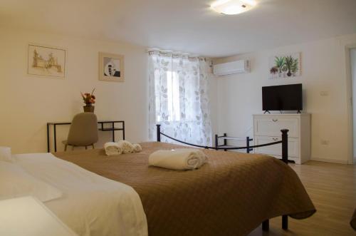 a bedroom with a bed with towels on it at Casa Alchisi - Teatro Romano Cozy Apartment in Catania