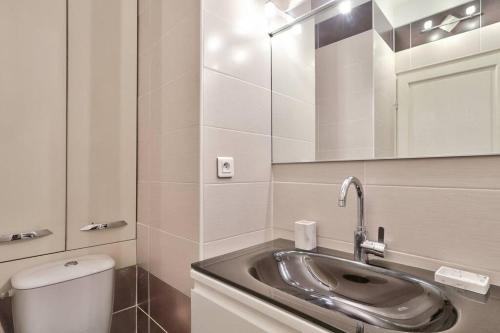 une salle de bain avec un lavabo, des toilettes et un miroir dans l'établissement L29 Lenval beach at 1min walk to Sea front AC Balcony, à Nice