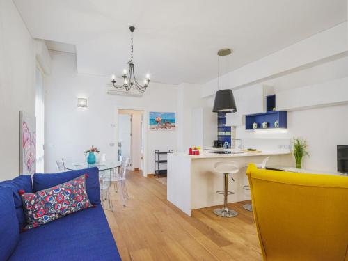 un soggiorno e una cucina con divano blu di Apartment Appartamento Amedeo by Interhome a Viareggio