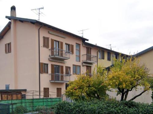 un gran edificio blanco con una valla verde delante de él en Apartment Il Castello by Interhome, en Casciago