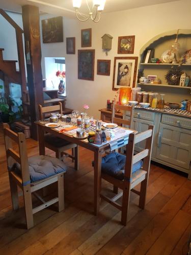 a dining room with a table and chairs and a kitchen at Yr Hen Farcdy in Talsarnau