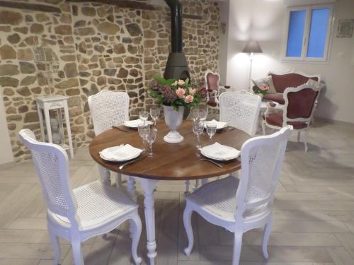 a wooden table with white chairs and a dining room at Chambres d'Hôtes L'Escale in Émeringes
