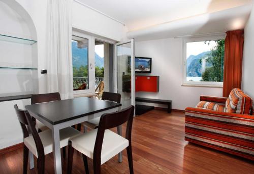 a living room with a table and chairs and a couch at Holiday Apartments Bellariva in Riva del Garda