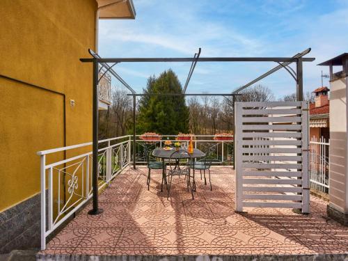 eine Terrasse mit einem Tisch und einem Zaun auf dem Balkon in der Unterkunft Apartment Mottarone by Interhome in Laveno-Mombello