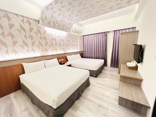 um quarto de hotel com duas camas e uma televisão em 花蓮包棟-天空樹民宿-近知卡宣公園 em Jian