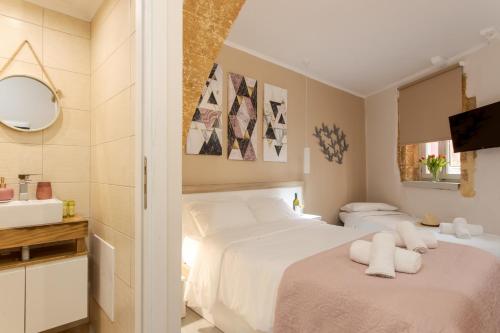 a bedroom with two white beds and a sink at Mitos Cozy Rooms in Chania