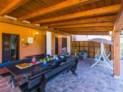 un patio con una larga mesa de madera y sillas en Holiday Home La Casina by Interhome, en Bibbona