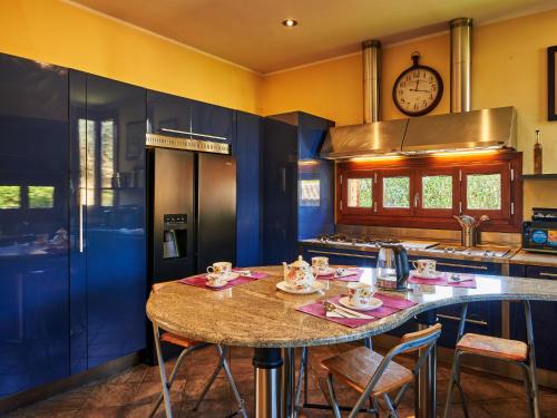 kuchnia ze stołem z krzesłami i zegarem w obiekcie Villa Villa Naviglio Grande by Interhome w mieście Corsico