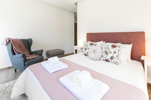 a bedroom with a bed with two towels on it at Maria da Vinha - Country House in Góis