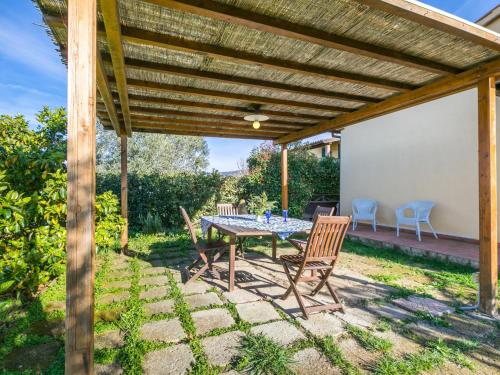 a patio with a table and chairs under a wooden pergola at Apartment Lavender by Interhome in Santa Luce