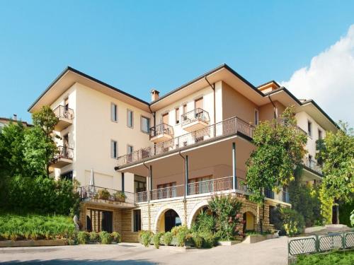 un edificio de apartamentos con balcones y árboles en Apartment Panorama-2 by Interhome, en Costermano