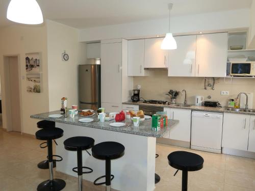 a kitchen with a counter with bar stools in it at Apartment Roy's place by Interhome in Portimão