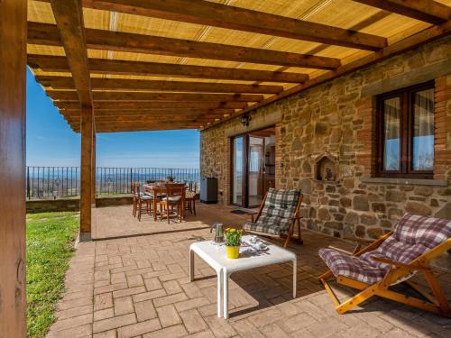 a patio with chairs and a table and a stone building at Holiday Home Civitella by Interhome in Scansano