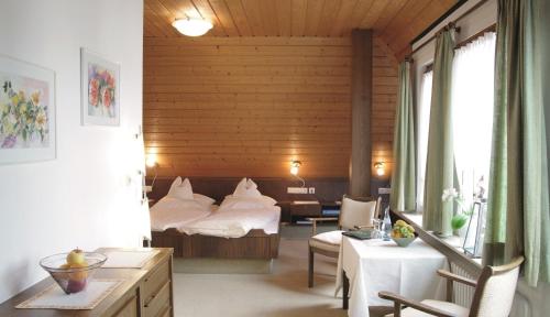 a bedroom with a bed and a table and chairs at Land-gut-Hotel Landgasthof Hotel Ochsen in Schömberg