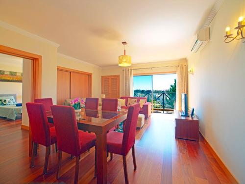 ein Esszimmer mit einem Tisch und roten Stühlen in der Unterkunft Apartment Sunflower by Interhome in Albufeira