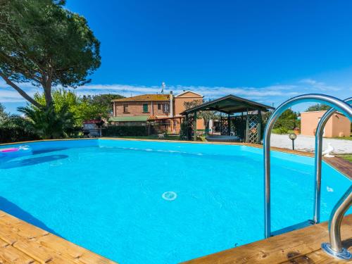 uma piscina com água azul em frente a uma casa em Apartment Gino by Interhome em Bibbona