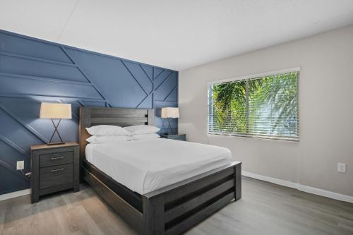a bedroom with a bed with a blue accent wall at Avenida in Tampa