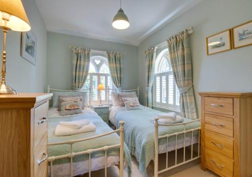 2 Betten in einem Schlafzimmer mit 2 Fenstern in der Unterkunft South Lodge in Corton