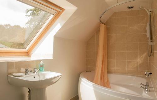 a bathroom with a sink and a toilet and a window at Old School in Dunan