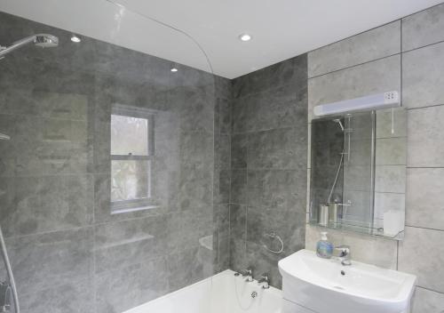 a bathroom with a shower and a sink and a toilet at Stones Throw in Southwold