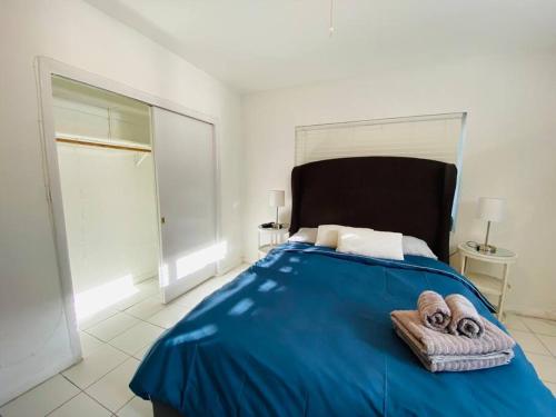 Un dormitorio con una cama azul con toallas. en Coral Gables / Coconut Grove area FREE parking, en Miami