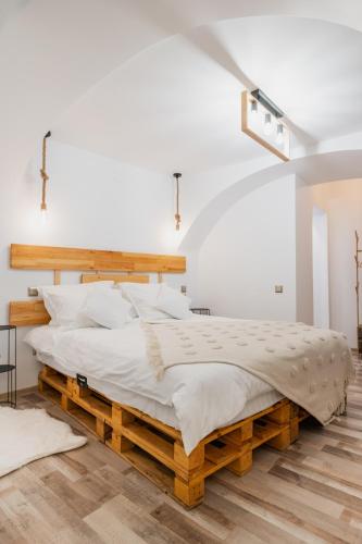 a bedroom with a large bed with a wooden frame at CoZee Studio - In inima Brasovului in Braşov