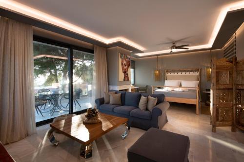 a living room with a couch and a bed at AVAL Riviera in Lagonissi