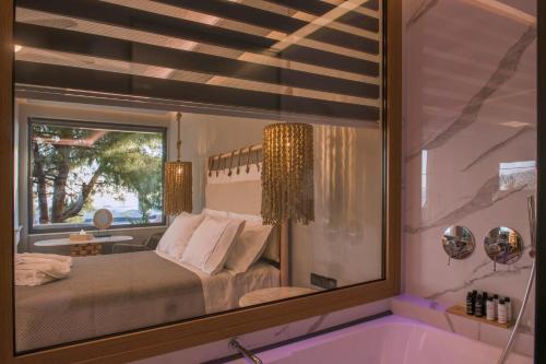 a mirror in a room with a bed and a window at AVAL Riviera in Lagonissi