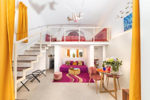 ein Wohnzimmer mit einem lila Sofa und einer Treppe in der Unterkunft Suite Belvedere Capri Exclusive Rooms in Capri