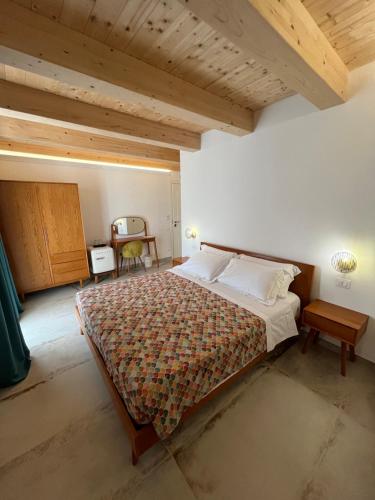 a bedroom with a large bed and a wooden ceiling at De LoCa Rooms in Tropea