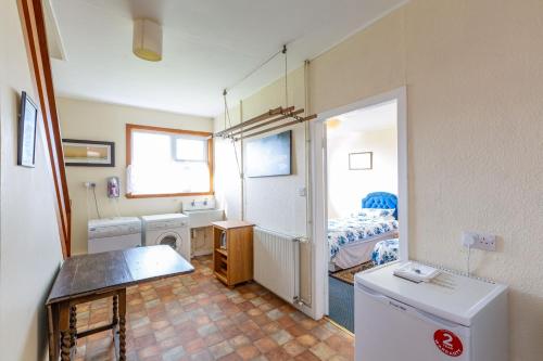 a small room with a washer and dryer and a bedroom at Dunrod in Kirkcudbright
