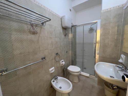 a bathroom with a toilet and a sink and a shower at Hotel Riviera in Alghero
