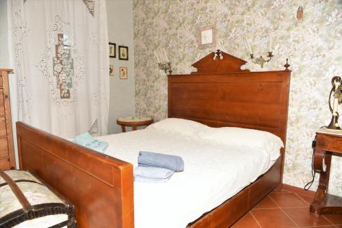 1 dormitorio con cama de madera y cabecero de madera en Casa gialla nel bosco, en Reggello