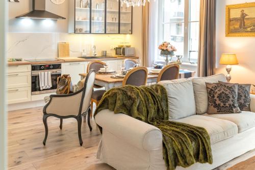 a living room with a couch and a table with chairs at Bea Garden Home - dwie sypialnie i taras in Elblag