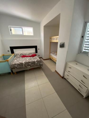 a bedroom with a bed and a dresser at Casa Chiquinha in Ribeira da Prata