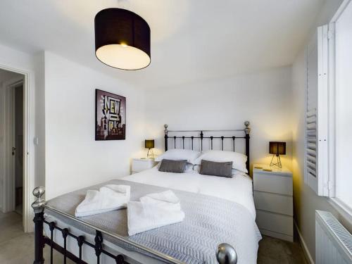 una camera da letto con un grande letto bianco con due lampade di The Snug Central Cosy Good Wi-Fi a Cheltenham