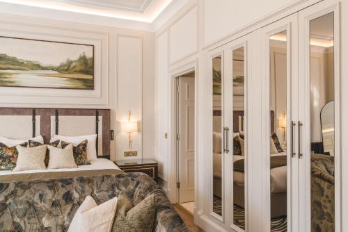 a bedroom with a king sized bed and glass doors at Dunkeld House Hotel in Dunkeld