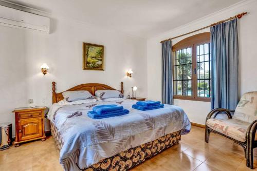 a bedroom with a bed with blue towels on it at La Isla Casa Barnaby in Platja de l'Arenal