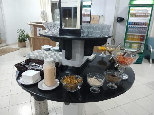 a black table with glasses and other items on it at HOTEL EXPRESS LORENZETTI in Guarapuava