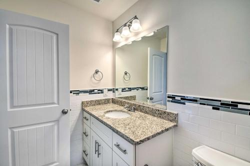 a white bathroom with a sink and a mirror at Cozy Cape Charles Apartment Walk to Beaches! in Cape Charles