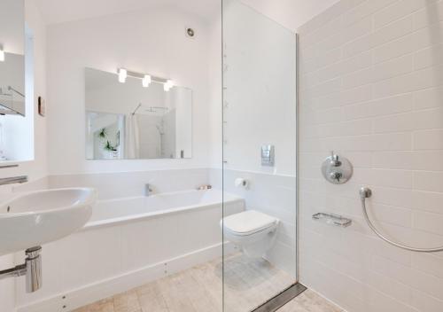 a bathroom with a sink and a toilet and a shower at Sundial Lodge in Wilby