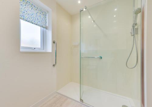 a shower with a glass door in a bathroom at Sunsette in Reydon