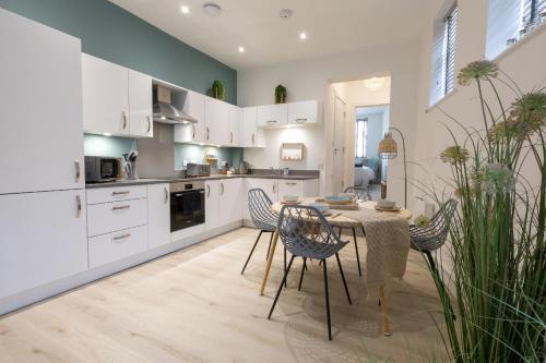 a kitchen with white cabinets and a table and chairs at Courtyard Retreat in Southampton