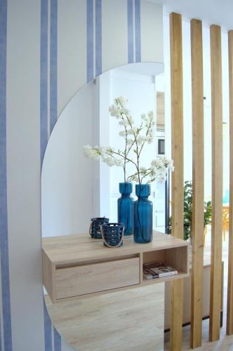 a mirror with three blue vases on a shelf at NEREIDAS Alojamiento exclusivo frente al mar in Corcubión