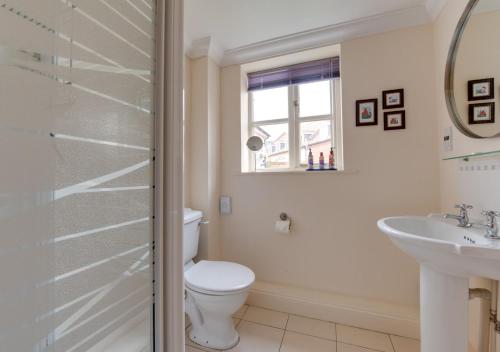 La salle de bains est pourvue de toilettes et d'un lavabo. dans l'établissement The Headmasters House, à Reydon