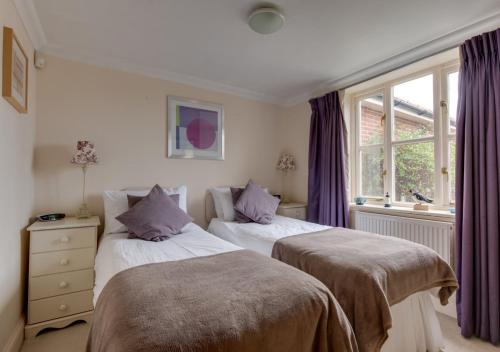 - une chambre avec 2 lits et une fenêtre dans l'établissement The Headmasters House, à Reydon