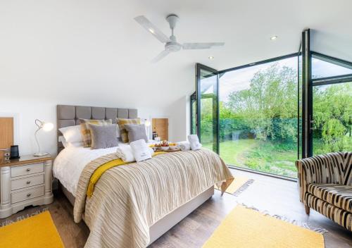 a bedroom with a bed and a large window at The Hatchery in Steeple Bumpstead