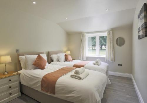 1 dormitorio con 2 camas y ventana en The Hen House en Beccles