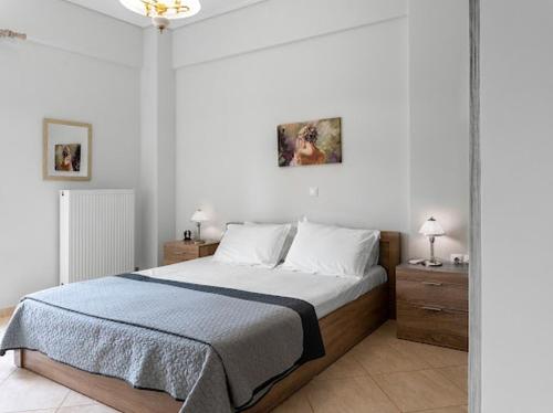 a bedroom with a large bed with white walls at Yellow house in Palaiá Fókaia