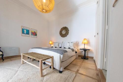 a white bedroom with a bed and a table at RIAD DAR C in Marrakech